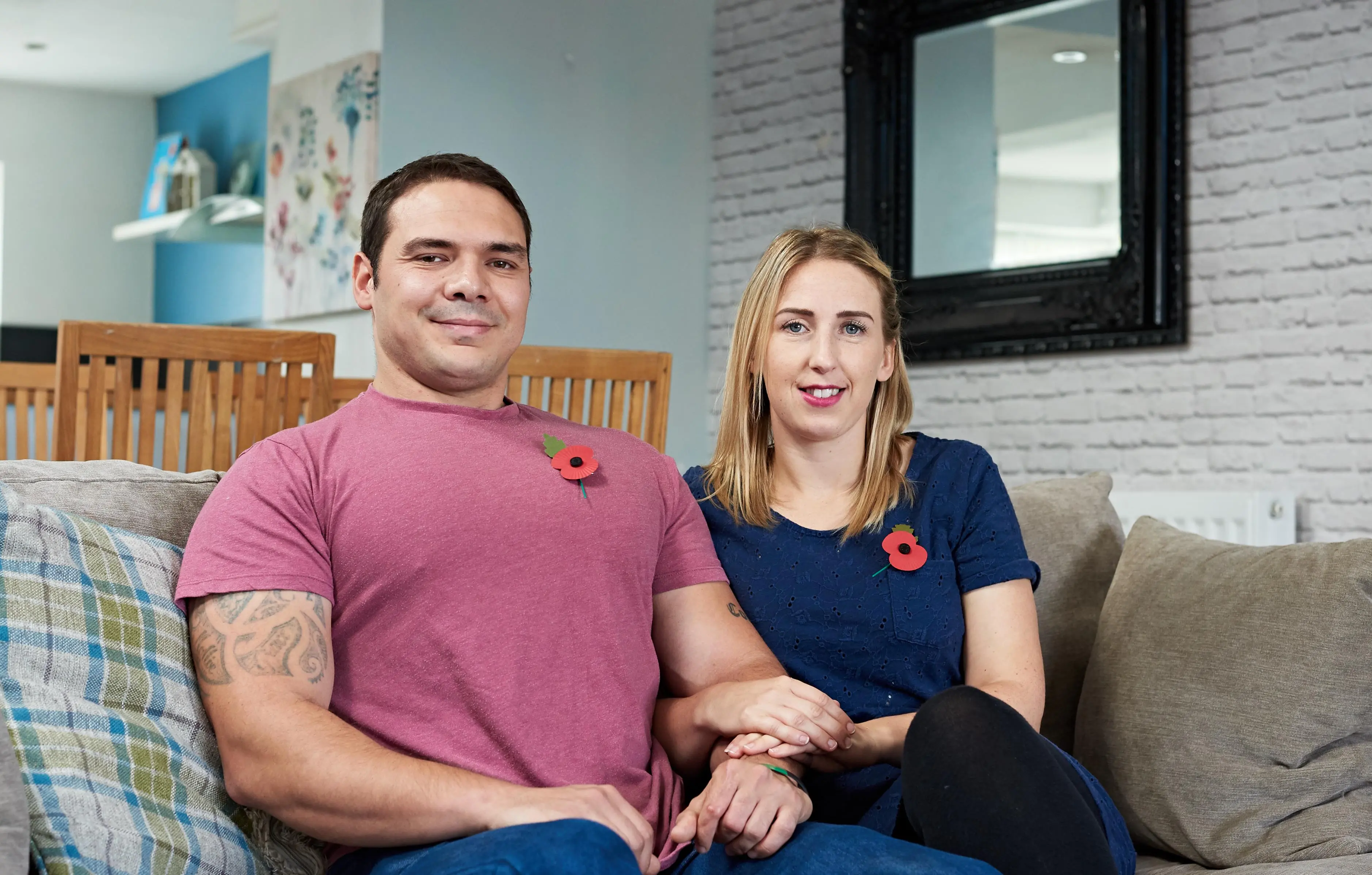 A couple who have received support from the Royal British Legion sitting on a sofa