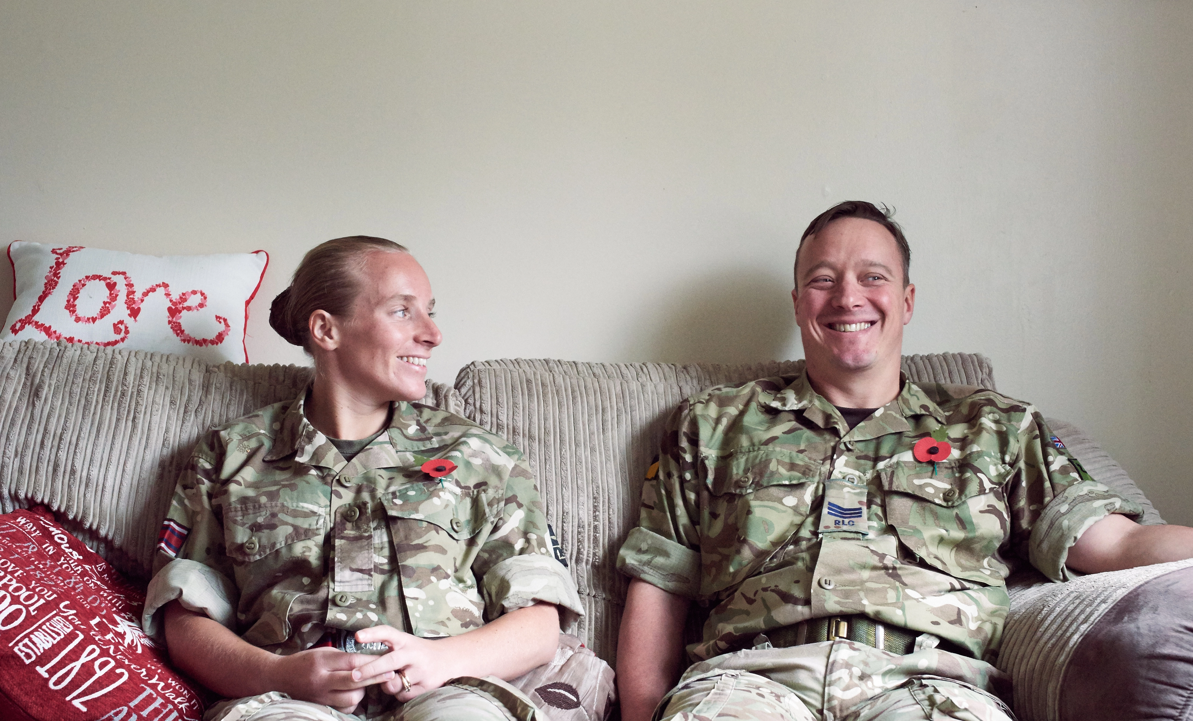 Military couple, and members of the Legion, sitting on sofa at home in battledress 