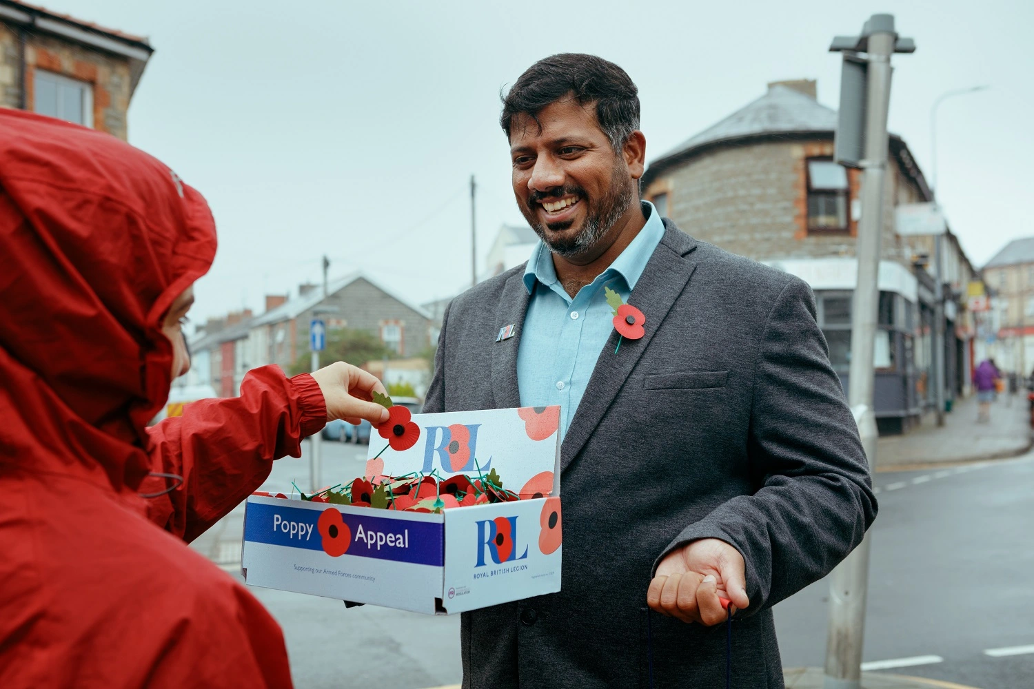 Mirza Shahzad giving a poppy to member of the public